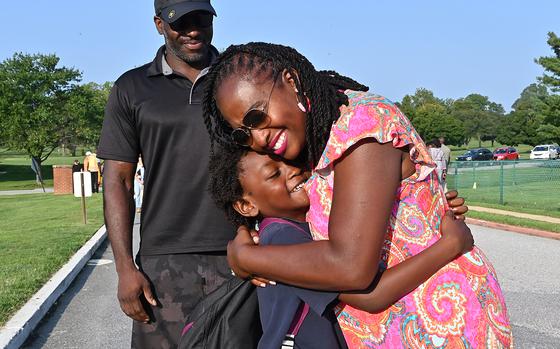 Head of School, Robyn Green welcomes 2nd grader, Adeyemi Ekundayo, 7, back to school as his father Adesina looks on. First day of classes at the Naval Academy Primary and Secondary School, welcoming their first ever 8th grade class on their 75th Anniversary. (Jeffrey F. Bill/Staff photo)