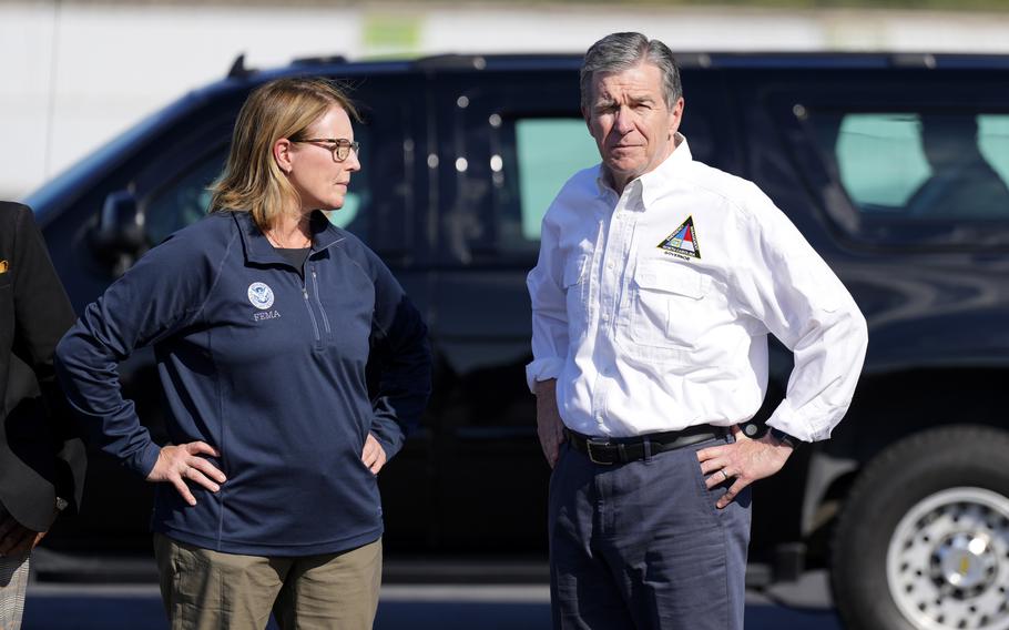 The governor of North Carolina and the administrator of FEMA stand in front of an SUV.