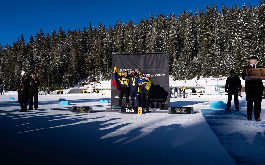 Competitors stand on stage with their medals