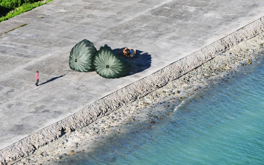 Residents of the Island of Mokil wave to the C-130 crew