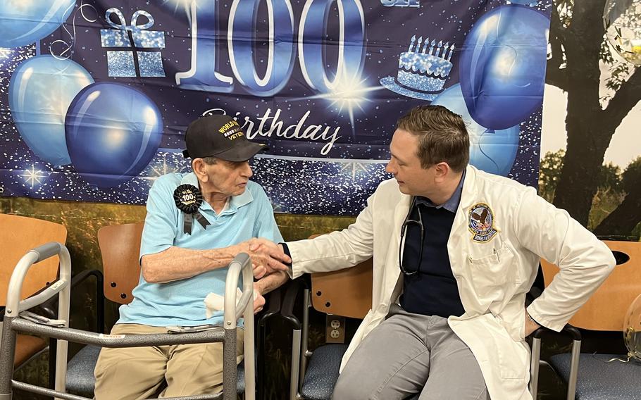 Lawrence Szydlowski shakes hands with Dr. Peter Sobiech of the Oak Lawn VA during his 100th birthday party June 21, 2024. 