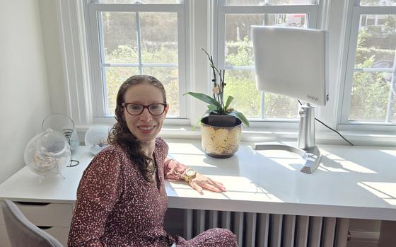 Miriam Cherry poses for a photo on Sept. 4 in her Larchmont, N.Y home, where she uses a light therapy device for seasonal affective disorder. She also devotes a corner of her garden to early blooming flowers as a sign that “this isn’t going to last forever. It will get better, and spring is on its way.”