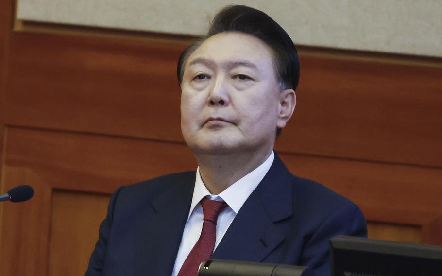 Impeached South Korean President Yoon Suk Yeol sits in a courtroom during a hearing.