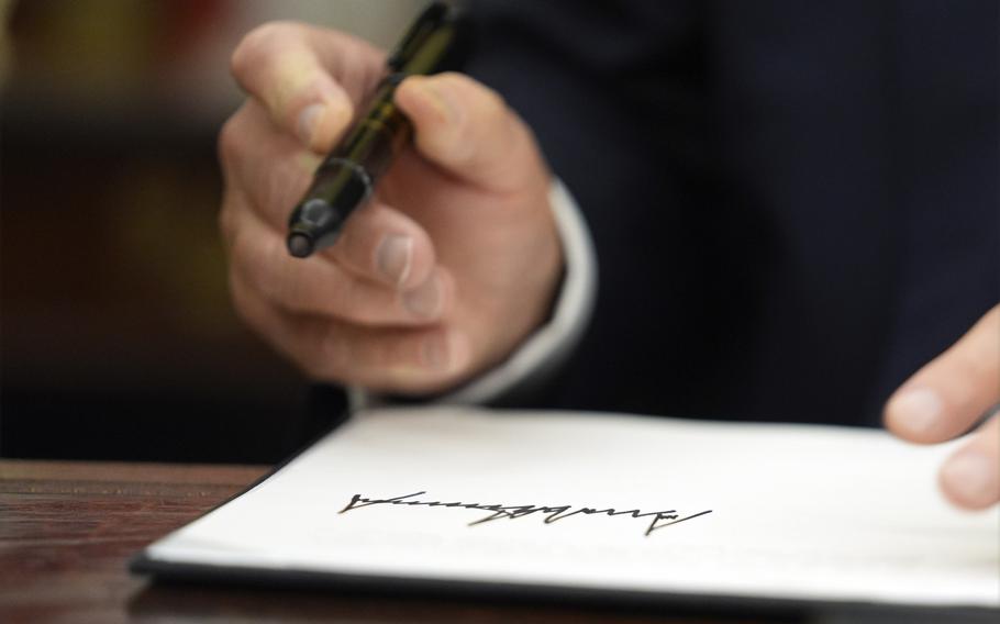 A closeup of Donald Trump’s pen and hand after signing an order.