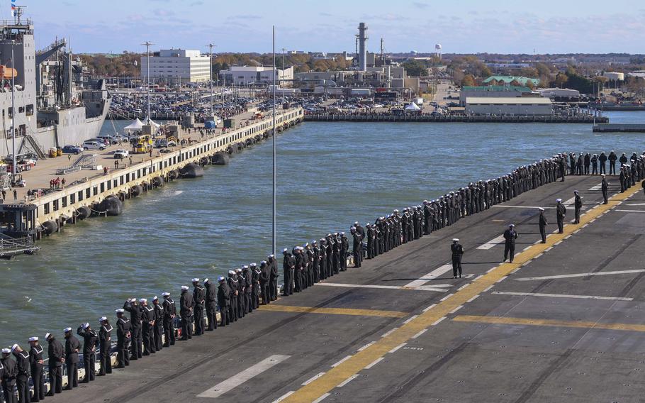 A line of sailors man the perimeter of the USS Wasp as it approaches Naval Station Norfolk, Va.