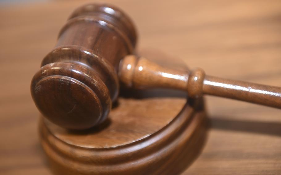 A gavel sits on a judge’s bench in a courtroom.