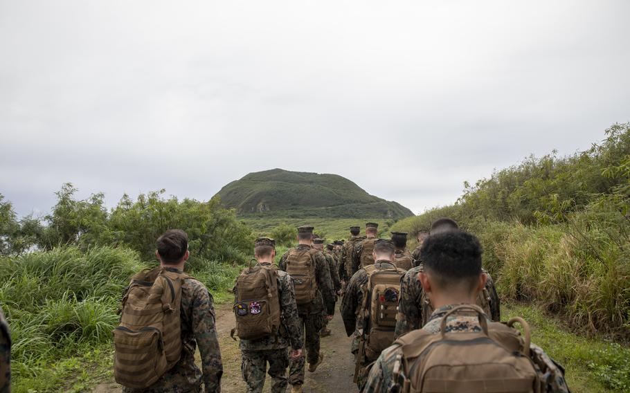 U.S. Marines and sailors hike towards Mt. Suribachi.