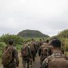 U.S. Marines and sailors hike towards Mt. Suribachi.