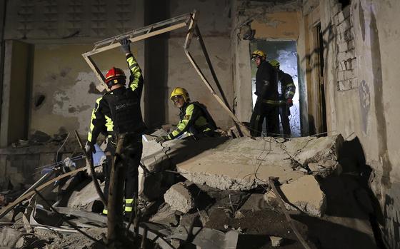 Emergency services workers move rubble after a Russian strike on a residential building in Kharkiv, Ukraine early Sunday Sept. 22, 2024. (Kharkiv Regional Military Administration via AP)