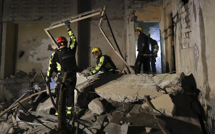 Emergency workers in the rubble after a Russian strike on an apartment building in Kharkiv