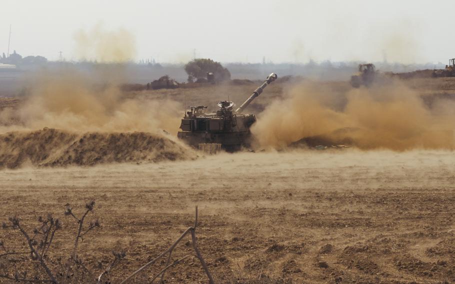 An Israeli tank fires artillery rounds toward the Gaza Strip near Kibbutz Be'eri, Israel, on Wednesday.