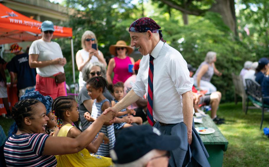 Congressman Jamie Raskin shakes hands with parade watchers in a lawn along Maple Ave in Takoma Park. He was the grand marshall for the parade.