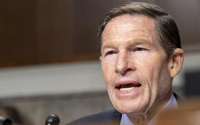 CLose-up view of a congressman speaking into a microphone during a hearing.