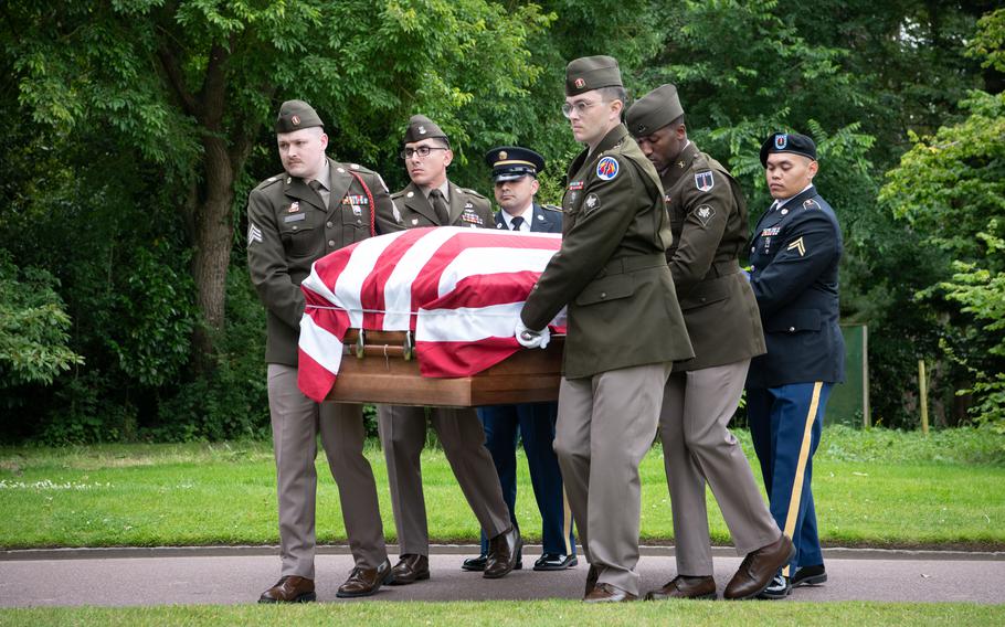 A military honor guard carries the flag-draped casket of Army 1st Lt. Nathan Baskind to his final resting place at Normandy American Cemetery in Colleville-sur-Mer, France, on June 23, 2024. Baskind died during World War II and had been buried with Germans in a mass grave. Germany transferred his remains to the U.S. in May.