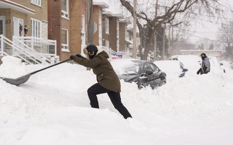 People shovel snow to dig out their cars