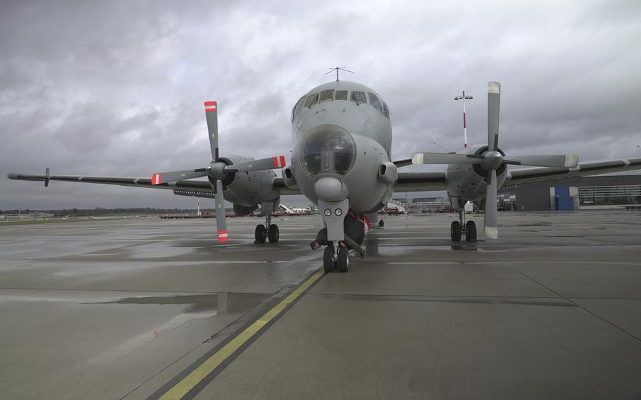 A pilot inspects the wheels of a surveillance plane.