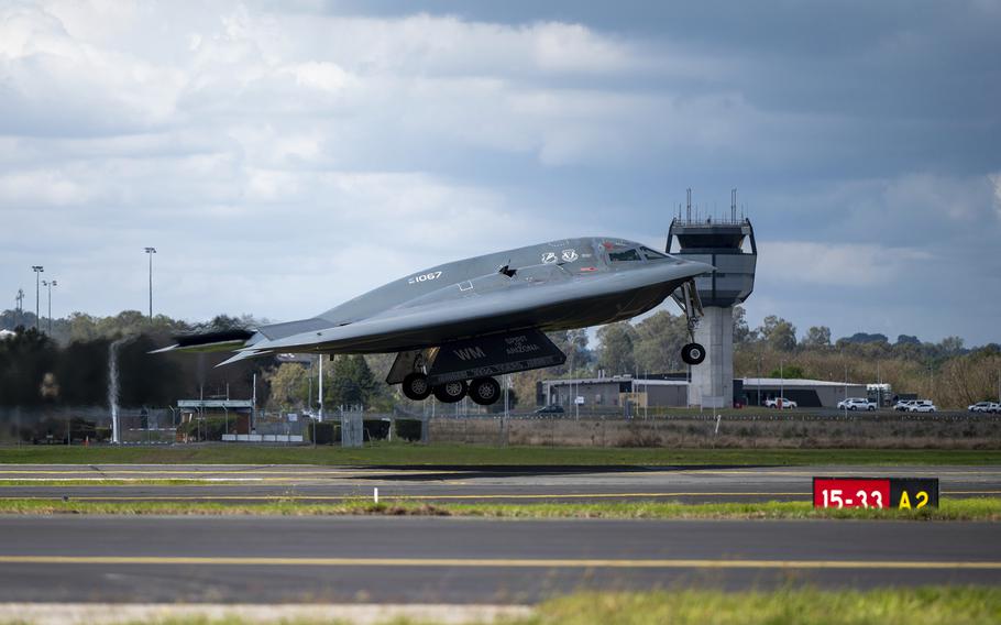 A stealth bomber lifts off from a runway.