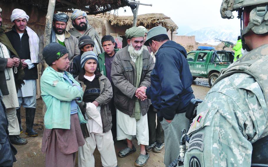 Afghan National Police Capt. Abdul Zaher, second from right, greets residents of the village of Marabad in the Pashtun Zarghun district of western Herat province on Feb. 8, 2010. U.S. and Afghan forces stopped in Marabad during a joint patrol to visit some police checkpoints in the district and stopped to talk with residents.