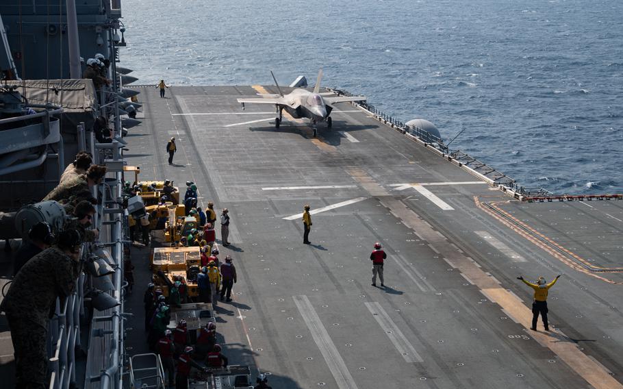 Sailors on deck as an F-35 taxis.