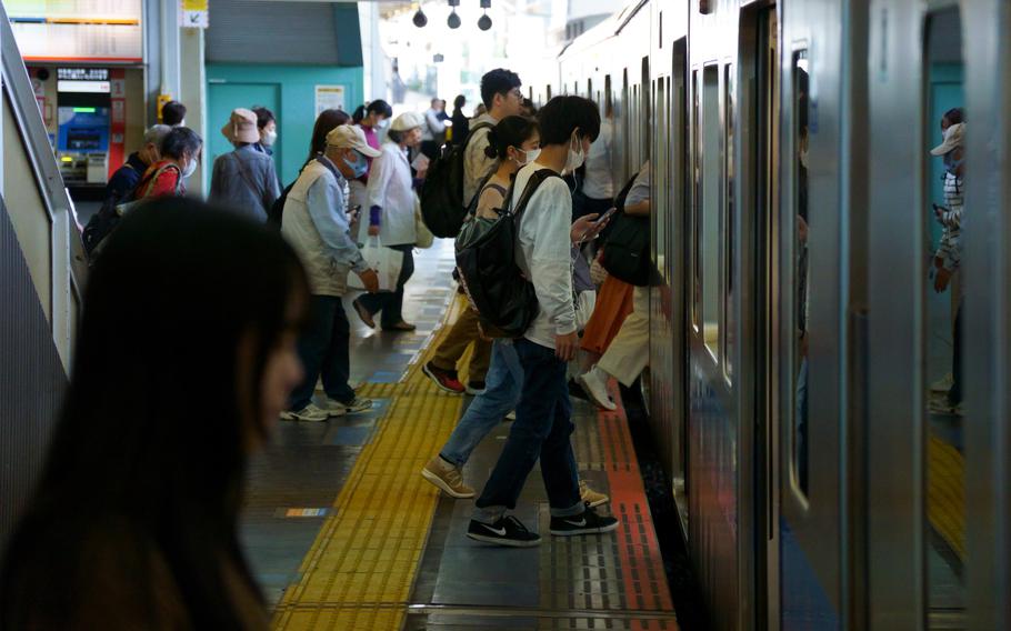 Commuters board a train in Tokyo, Thursday, Oct. 19, 2023.