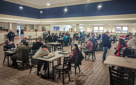 Airmen sit at tables inside O’Malley Dining Facility at Kunsan Air Base.