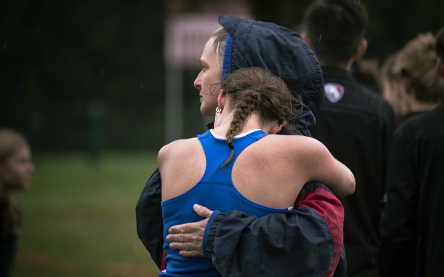 A runner embraces a supporter after completing the grueling 5,000-meter cross country course at Rose Barracks, Saturday, Sept. 14, 2024. 