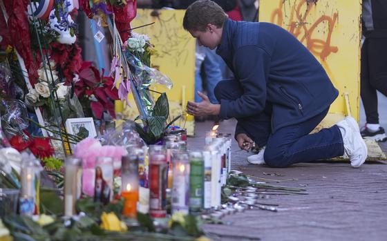 Nathan Williams, a University of New Orleans student, lights a candle at memorial on Bourbon Street for the victims of a deadly truck attack on New Year's Day in New Orleans, Friday, Jan. 3, 2025. (AP Photo/Gerald Herbert)