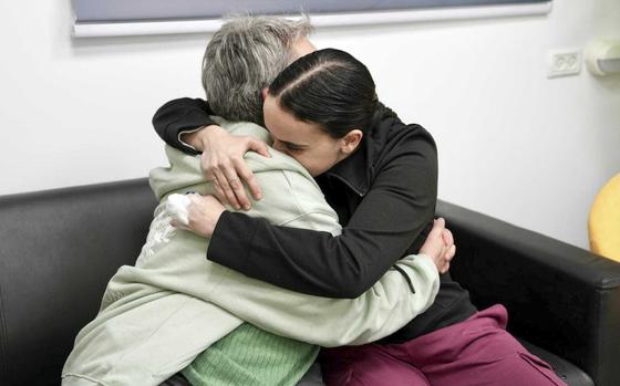 In this photo released by the Israeli Army, Emily Damari, right, and her mother Mandy use a smart phone near kibbutz Reim, southern Israel after Emily was released from captivity by Hamas militants in Gaza, Sunday, Jan. 19, 2025.  (Israeli Army via AP)