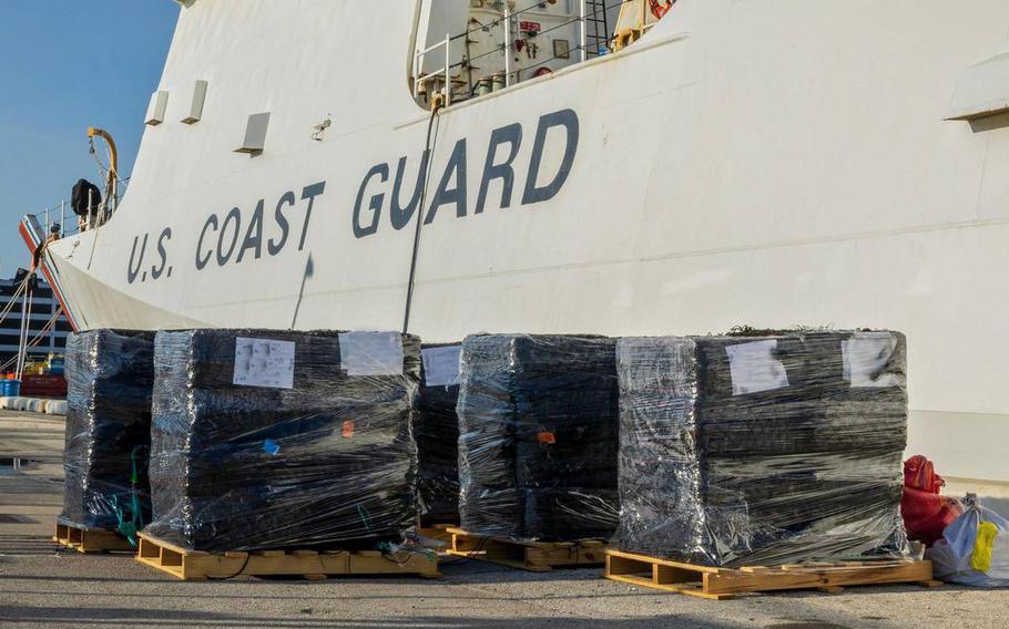 View of pallets in front of a Coast Guard cutter