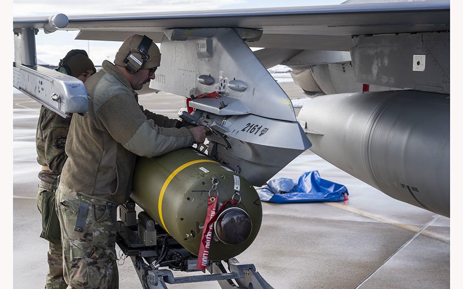 U.S. airmen load a CBU-87 (a cluster-bomb unit) onto an F-16 Fighting Falcon at Hill Air Force Base, Utah on January 11, 2023. 