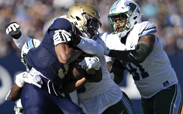 Navy quarterback Braxton Woodson is tackled by a group of Tulane defenders during the first half of an NCAA college football game, Saturday, Nov. 16, 2024, in Annapolis, Md. (AP Photo/Terrance Williams)