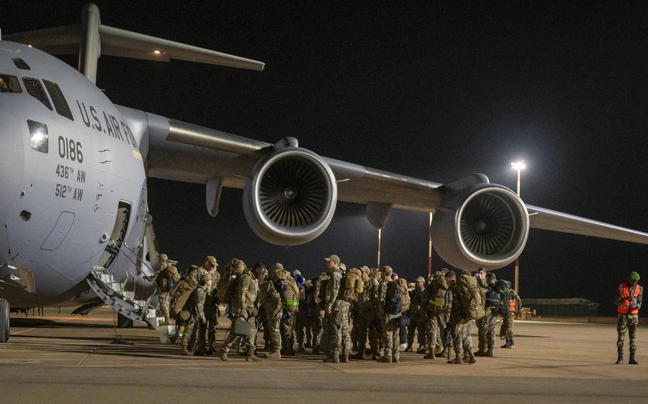 U.S. service members bid farewell to their colleagues as they board a U.S. Air Force C-17 aircraft departing Niamey, Niger. About 700 troops remain in Niger, where the military is withdrawing following a coup. The departure is expected to last through September.