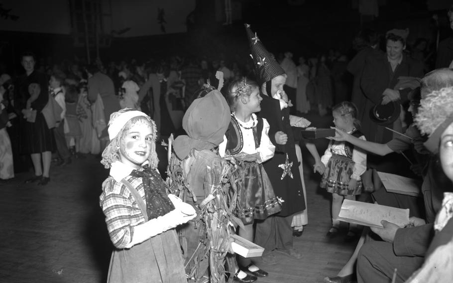 Raggedy Ann shoots a smile at the photographer as her and several other children —  also dressed up in their Halloween best —  stand before the costume contest judges.