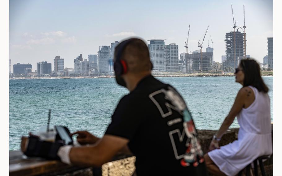 People gaze at the Mediterranean Sea from an outdoor cafe in Tel Aviv on Wednesday, July 31, 2024.