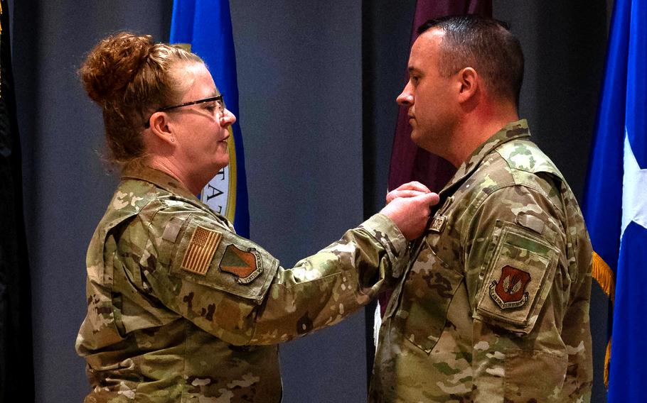 Brig. Gen. Adrienne Williams presents Master Sgt. Matthew Parker with the Distinguished Flying Cross 