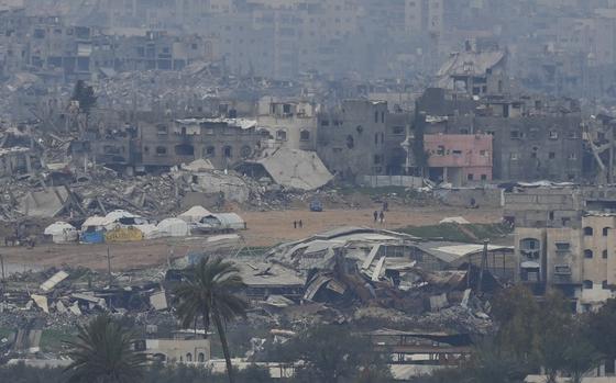 Palestinians are seen near destroyed buildings by Israeli bombardments inside the northern Gaza Strip as seen from southern Israel, Sunday, Feb. 9, 2025. (Photo/Ohad Zwigenberg)