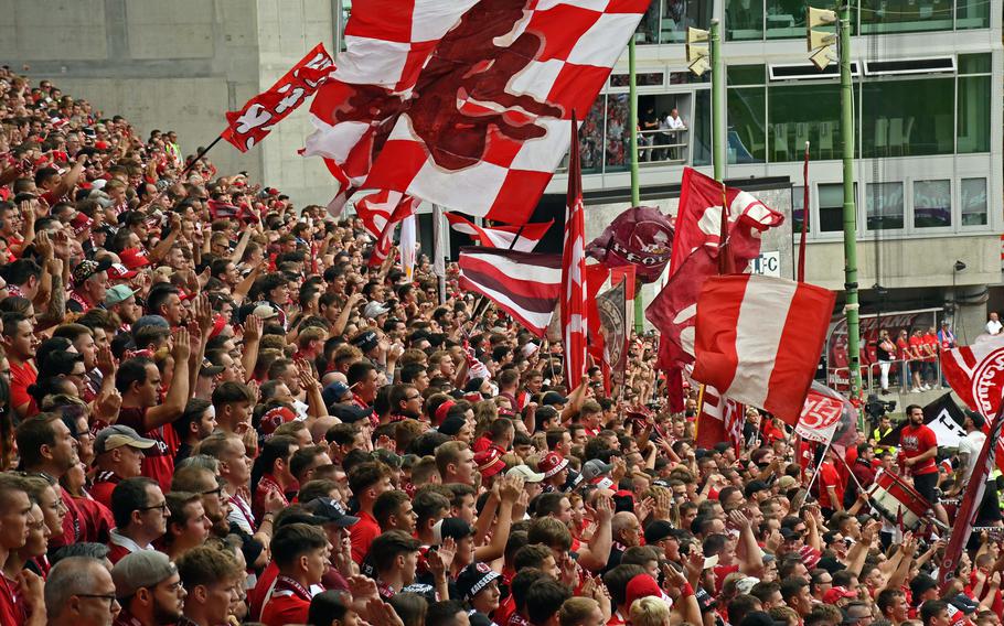 Supporters wave flags and cheer during an FC Kaiserslautern soccer game 