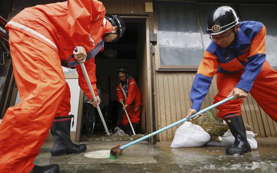 Firefighters help clean up floodwater out of a house in Ogaki, central Japan, Saturday, Aug. 31, 2024, following a tropical storm in the area. (Natsumi Yasumoto/Kyodo News via AP)