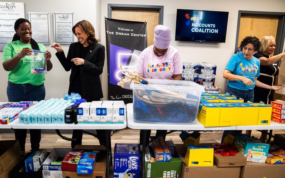 Harris shares a moment with a volunteer preparing emergency aid packages at a Charlotte donation center.