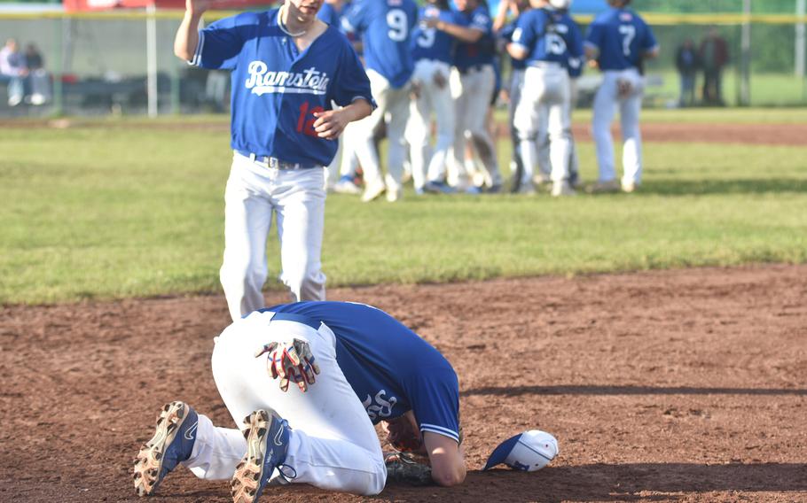 While most of the team celebrates near the pitching mound, Ramstein’s Caden Nims falls to the ground Friday, May 24, 2024, overcome with emotion after his team won the title. Freshman Lukas Bali approaches him.