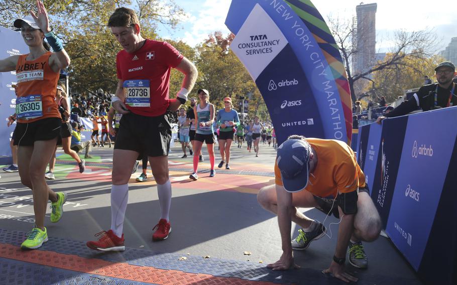 Runners cross the finish line of the 2016 New York City Marathon. Experts say that rest during marathon runs should be taken as seriously as training.