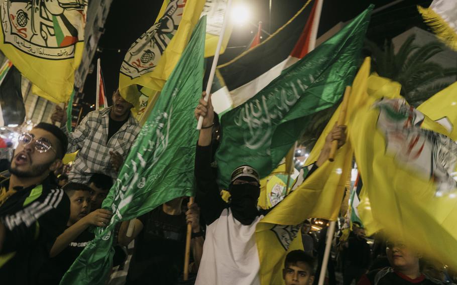 A march of Fatah party supporters in the city center of Nablus, West Bank, on Tuesday. The march was initiated by Fatah, but Hamas flags (in green) also appeared in the crowd. 