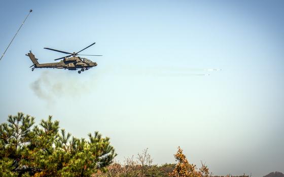 A helicopter shoots two porjectiles over a desert setting.