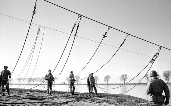 West Germany, April, 1954: Soldiers from the 109th Engineer Battalion raise guy wires for a 60-ton bridge being built across the Rhine River during an exercise.

Looking for Stars and Stripes’ historic coverage? Subscribe to Stars and Stripes’ historic newspaper archive! We have digitized our 1948-1999 European and Pacific editions, as well as several of our WWII editions and made them available online through https://starsandstripes.newspaperarchive.com/

META TAGS: U.S. Army; 109th Engineer Battalion; bridge; Germany