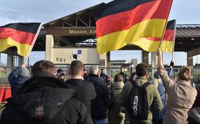 Protesters wave German flags and shout outside the main gate of Spangdahlem Air Base, Germany, on Nov. 24, 2024. The demonstration was the second one held since a Spangdahlem airman accused of killing German national Michael Ovsjannikov was acquitted last month.