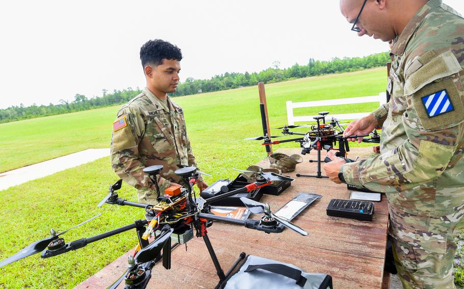 Army Spc. Adonis Sanchez, left, and Pfc. Jacob Morgan prepare the hexacopter drones that they built during a small drone building class at Fort Stewart for flight at a small airfield just off the the Georgia Army post on July 26, 2024. The 3rd Infantry Division soldiers were part of the inaugural drone building class run by the division’s Marne Innovation Center. 