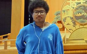 A teenaged boy with glasses in a blue sweatshirt is shown.