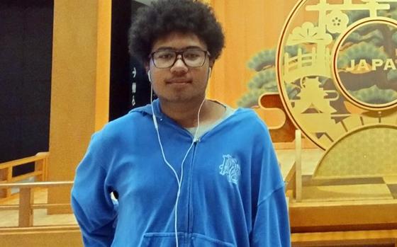 A teenaged boy with glasses in a blue sweatshirt is shown.