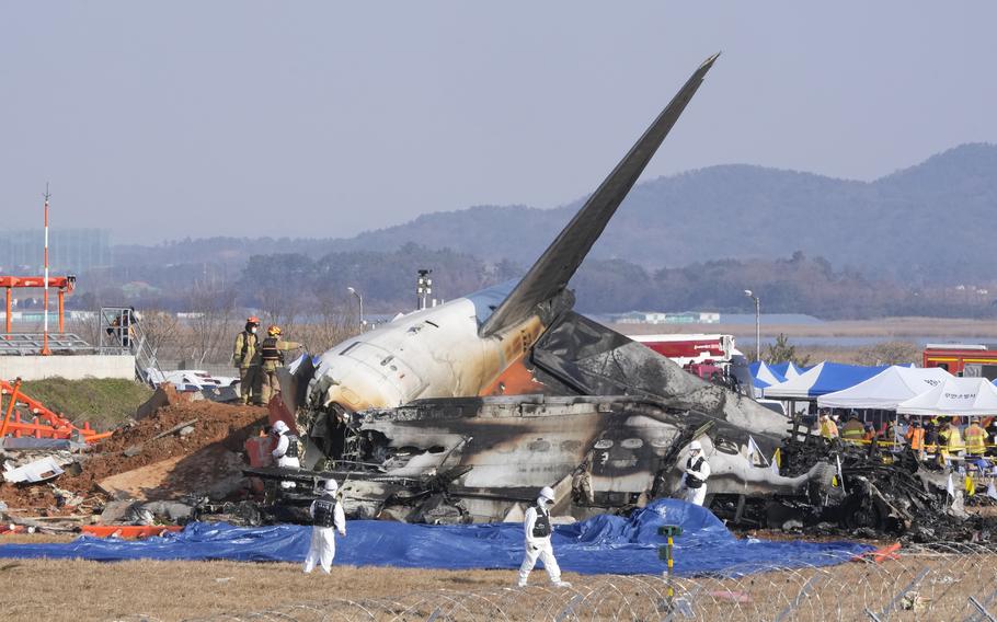 Firefighters and rescue team members work near the wreckage