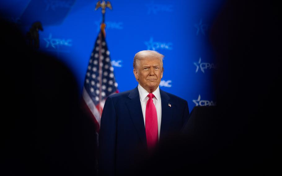 President Trump seen in between the silhouttes of people in front of him.